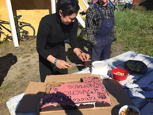 Director of the Arctic Nomads project Pipaluk Løgstrup cuts the cake.